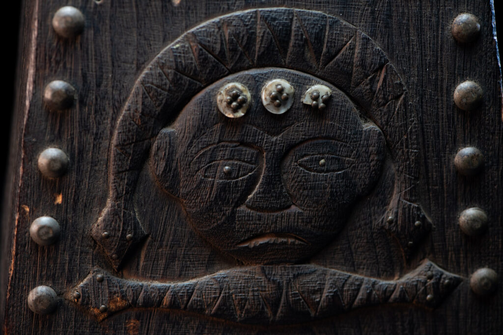 Paiwan tribe shaman box carved with a human head Wearing a two-headed snake as a headdress and other one on his neck. The edge of the shaman's box is studded with upholstery nails.