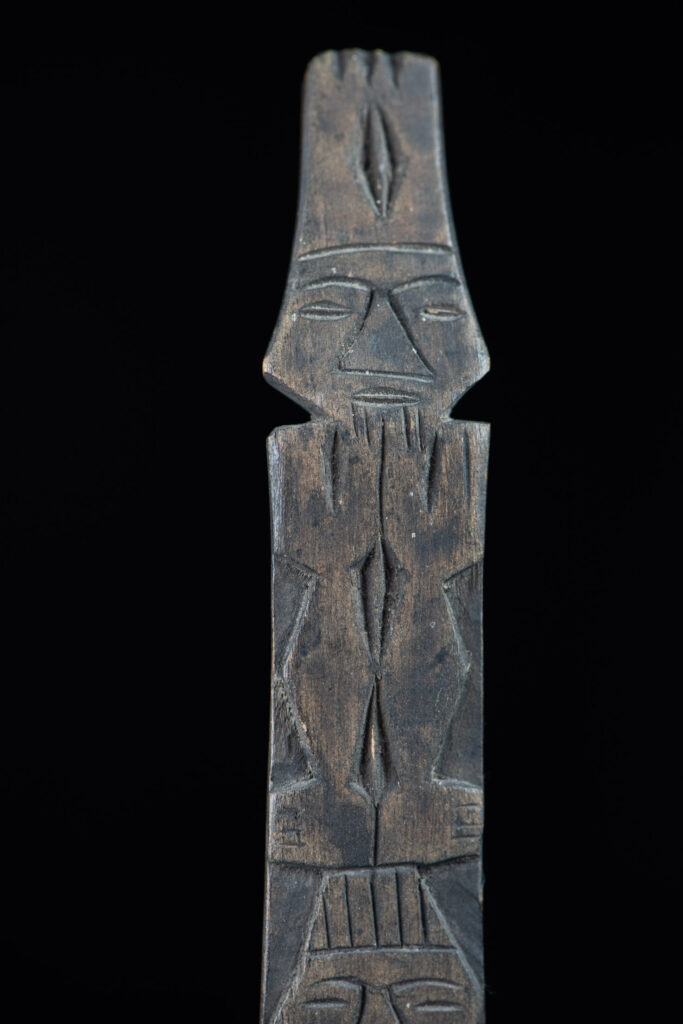 Ancient spoon from the Paiwan tribe, carved with two standing figures, one above the other.
