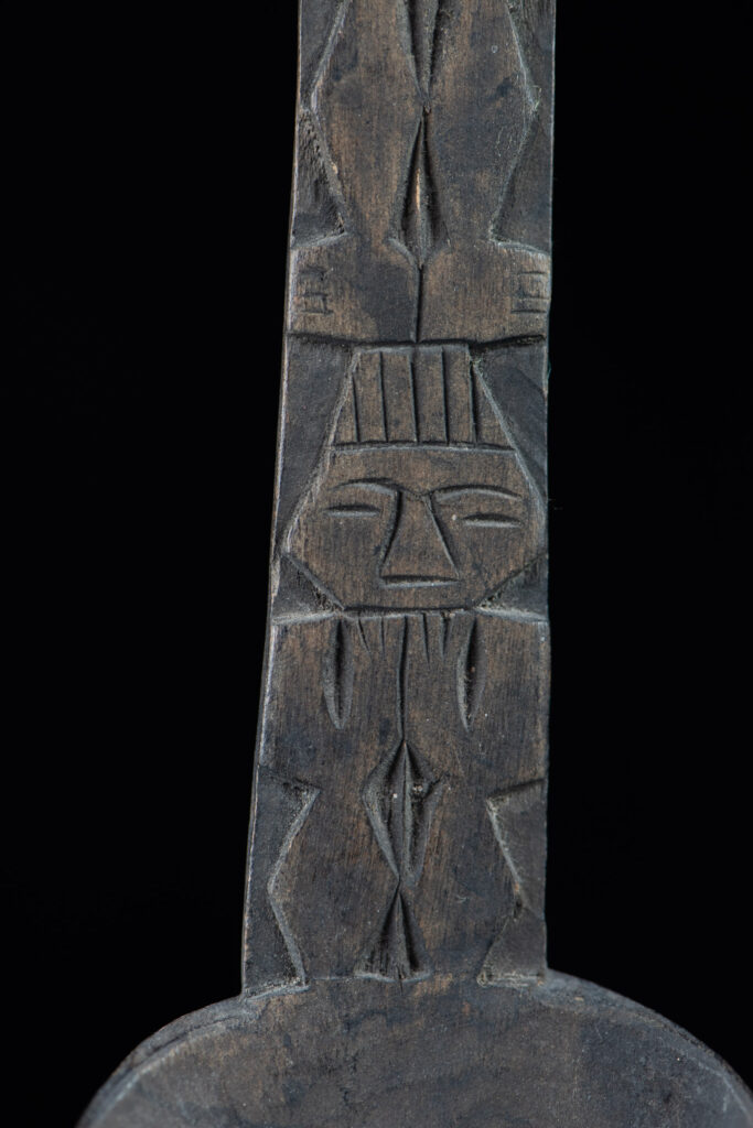 Ancient spoon from the Paiwan tribe, carved with two standing figures, one above the other.