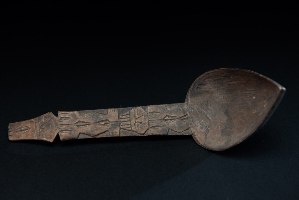 Ancient spoon from the Paiwan tribe, carved with two standing figures, one above the other.