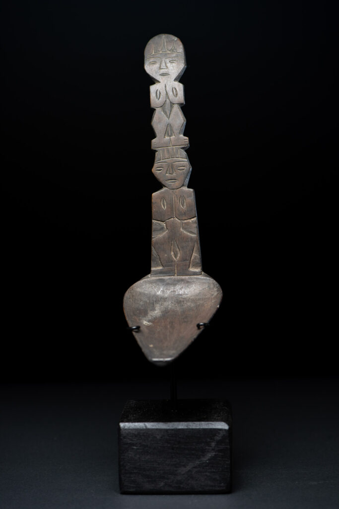 Ancient spoon from the Paiwan tribe, carved with two standing figures, one above the other.