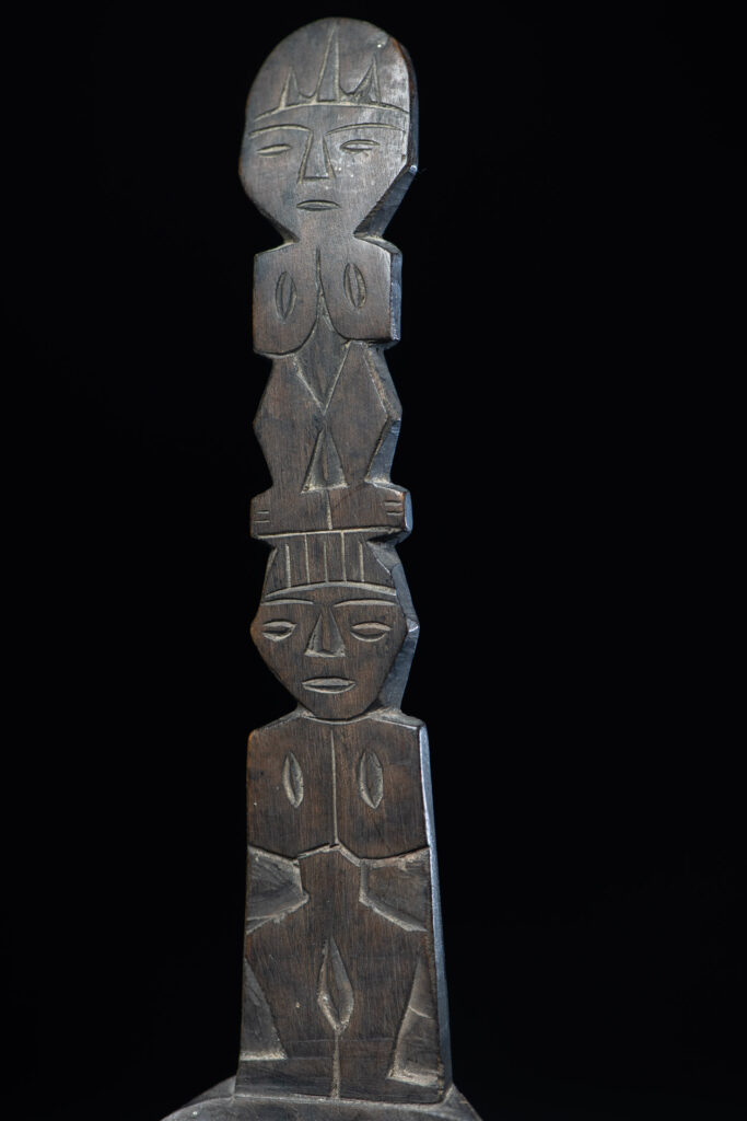 Ancient spoon from the Paiwan tribe, carved with two standing figures, one above the other.