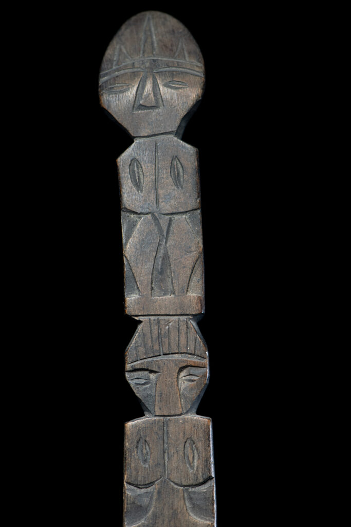 Ancient spoon from the Paiwan tribe, carved with two standing figures, one above the other.