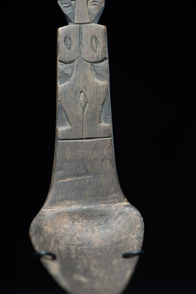 Ancient spoon from the Paiwan tribe, carved with two standing figures, one above the other.