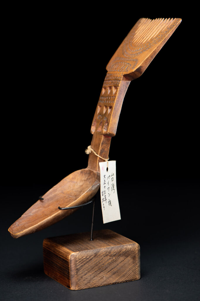 Paiwan tribe ancient spoon and comb together done inside a yellow wood and carved with geometric pattern .