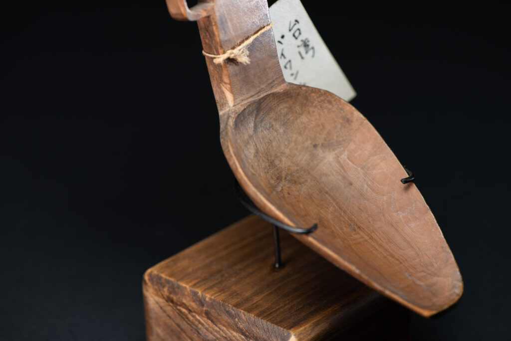 Paiwan tribe ancient spoon and comb together done inside a yellow wood and carved with geometric pattern .