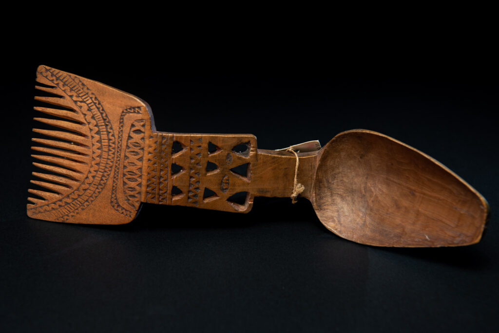 Paiwan tribe ancient spoon and comb together done inside a yellow wood and carved with geometric pattern .