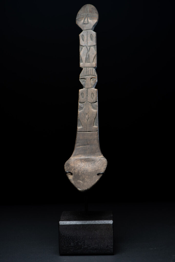Ancient spoon from the Paiwan tribe, carved with two standing figures, one above the other.