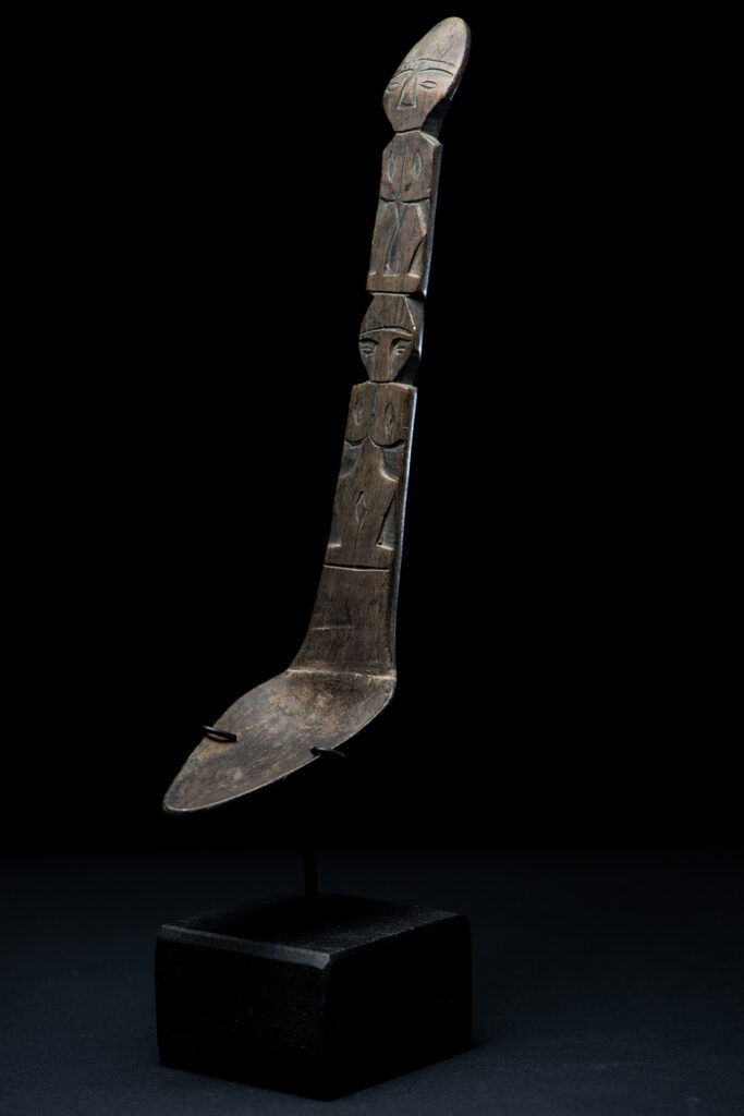 Ancient spoon from the Paiwan tribe, carved with two standing figures, one above the other.