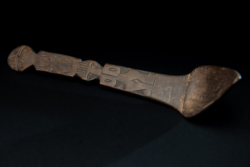 Ancient spoon from the Paiwan tribe, carved with two standing figures, one above the other.