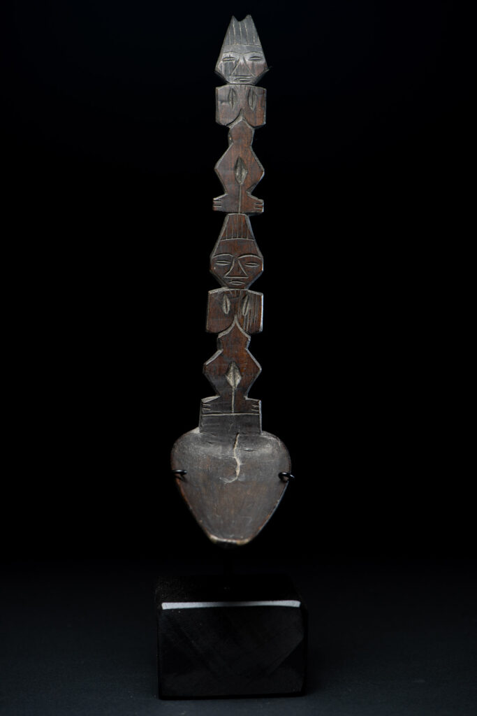 Ancient spoon from the Paiwan tribe, carved with two standing figures, one above the other.