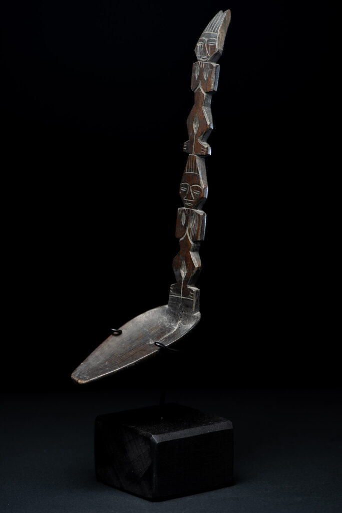Ancient spoon from the Paiwan tribe, carved with two standing figures, one above the other.