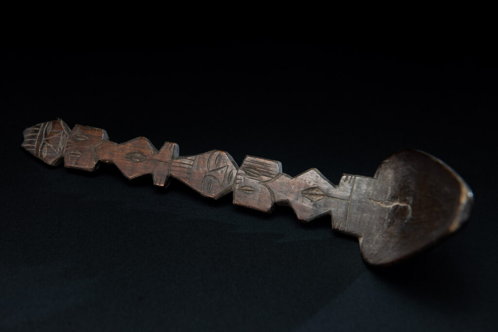 Ancient spoon from the Paiwan tribe, carved with two standing figures, one above the other.