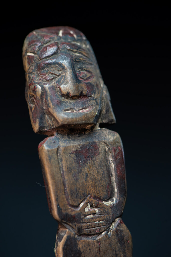 Paiwan tribe ancient wood spoon carved with a standing picture of warrior with a two-headed snake encircling the head of the upper figure. Some red tint remains.