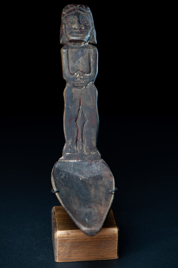 Paiwan tribe ancient wood spoon carved with a standing picture of warrior with a two-headed snake encircling the head of the upper figure. Some red tint remains.