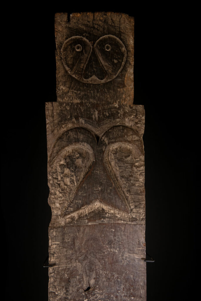 Rare and massive early 19th-century panel from the East Coast Paiwan tribe, carved in the Taimali style. It features a prominent central nose, a stylized face at the top, and another face carved at the bottom — a characteristic design of the Southeastern Paiwan tradition.