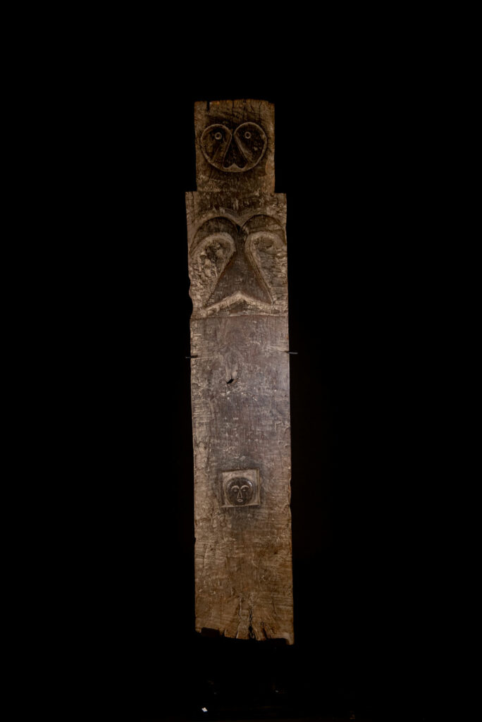 Rare and massive early 19th-century panel from the East Coast Paiwan tribe, carved in the Taimali style. It features a prominent central nose, a stylized face at the top, and another face carved at the bottom — a characteristic design of the Southeastern Paiwan tradition.