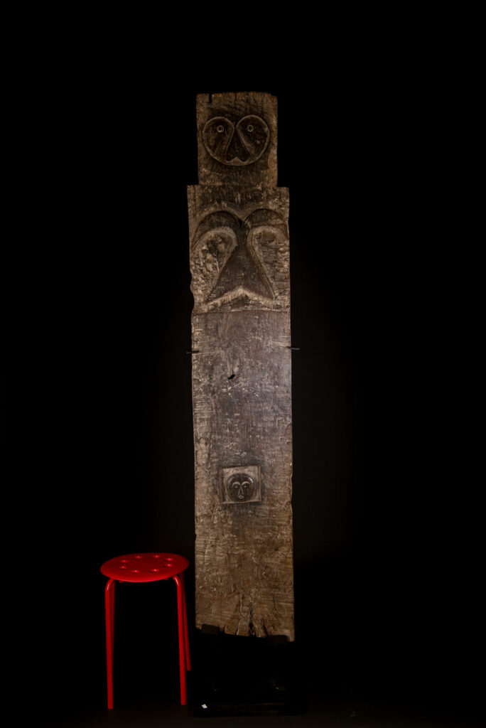 Rare and massive early 19th-century panel from the East Coast Paiwan tribe, carved in the Taimali style. It features a prominent central nose, a stylized face at the top, and another face carved at the bottom — a characteristic design of the Southeastern Paiwan tradition.
