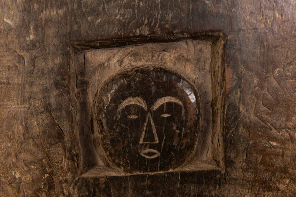 Rare and massive early 19th-century panel from the East Coast Paiwan tribe, carved in the Taimali style. It features a prominent central nose, a stylized face at the top, and another face carved at the bottom — a characteristic design of the Southeastern Paiwan tradition.