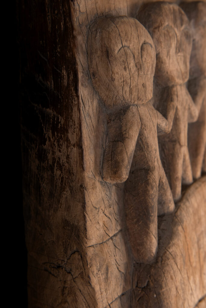 Rare and massive 19th-century Paiwan tribe shamanic ancestor panel, carved with a thick relief depicting a shaman with an oversized head crowned with multiple human faces — symbolizing his responsibility over the tribe’s spiritual and physical well-being.