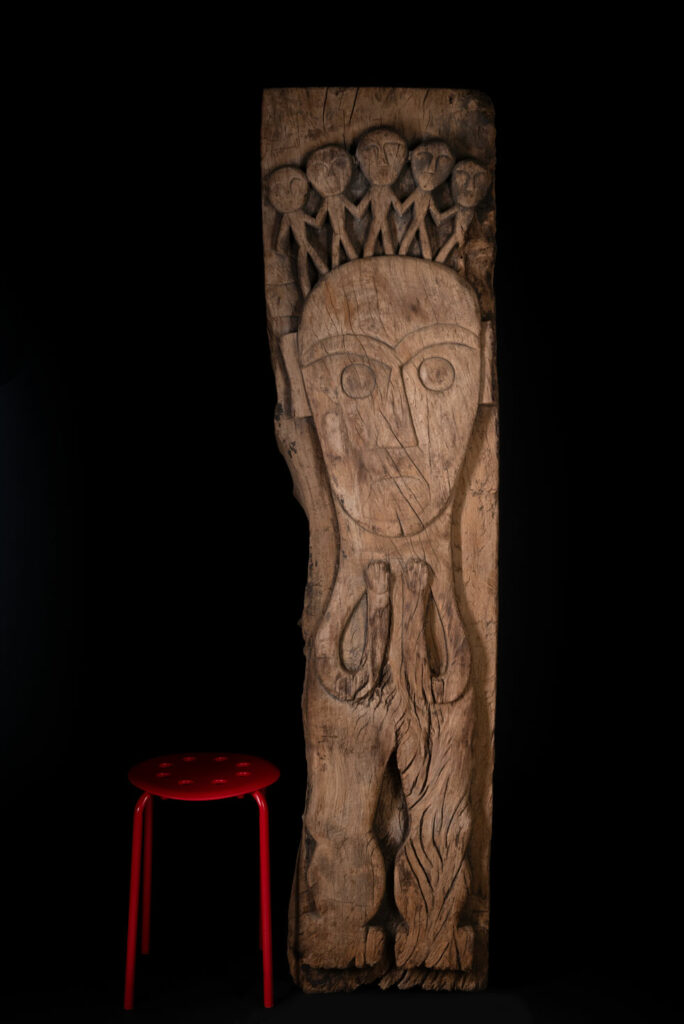 Rare and massive 19th-century Paiwan tribe shamanic ancestor panel, carved with a thick relief depicting a shaman with an oversized head crowned with multiple human faces — symbolizing his responsibility over the tribe’s spiritual and physical well-being.