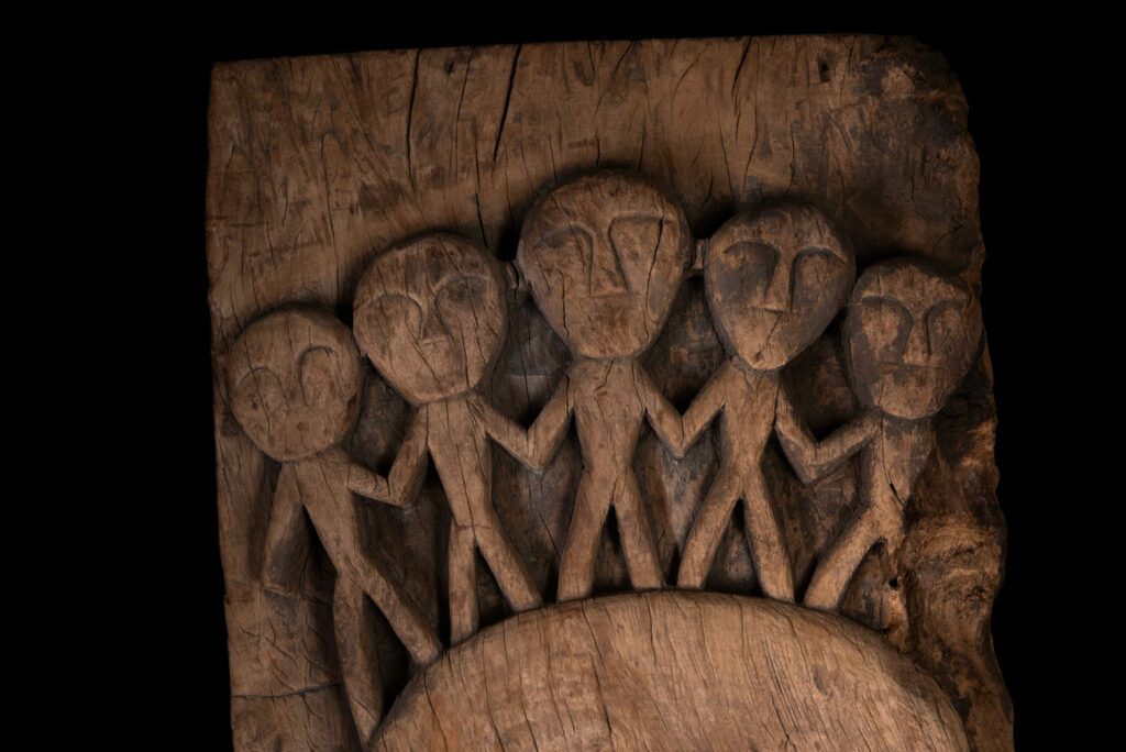 Rare and massive 19th-century Paiwan tribe shamanic ancestor panel, carved with a thick relief depicting a shaman with an oversized head crowned with multiple human faces — symbolizing his responsibility over the tribe’s spiritual and physical well-being.