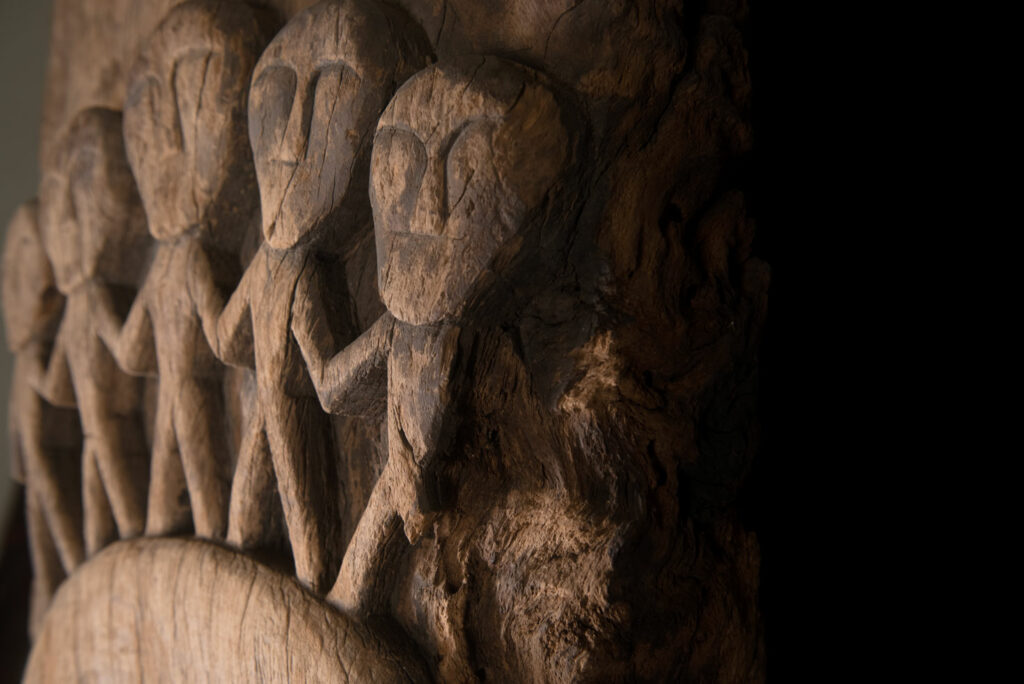 Rare and massive 19th-century Paiwan tribe shamanic ancestor panel, carved with a thick relief depicting a shaman with an oversized head crowned with multiple human faces — symbolizing his responsibility over the tribe’s spiritual and physical well-being.