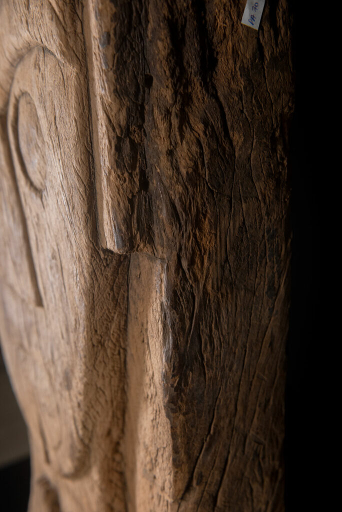 Rare and massive 19th-century Paiwan tribe shamanic ancestor panel, carved with a thick relief depicting a shaman with an oversized head crowned with multiple human faces — symbolizing his responsibility over the tribe’s spiritual and physical well-being.