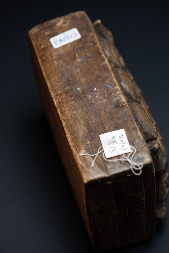 Paiwan tribe ancient shaman box in wood carved with two designs mirrored of three human head set up on a two heads snake .