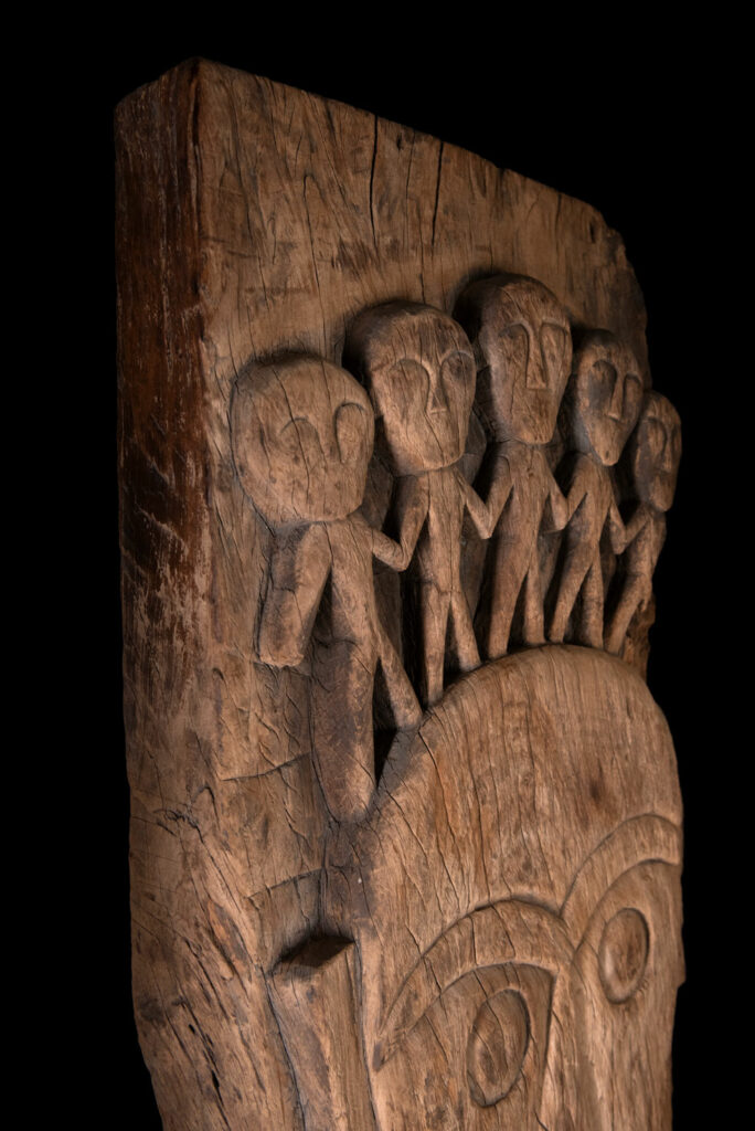 Rare and massive 19th-century Paiwan tribe shamanic ancestor panel, carved with a thick relief depicting a shaman with an oversized head crowned with multiple human faces — symbolizing his responsibility over the tribe’s spiritual and physical well-being.