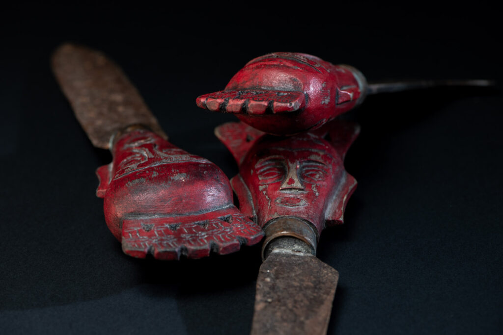 Set of three shamanic knifes from the Paiwan tribe, intended for sacred rituals. Painted in red and carved with a human head surmounted by additional heads, it reflects the typical style of Paiwan shamans and healers, who are in charge of the tribe’s physical and spiritual well-being. These shamanic knifes were used to cut herbs, beetle nuts, little animals and each one have a precise function.