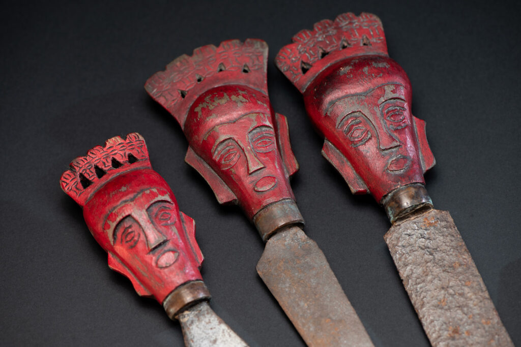 Set of three shamanic knifes from the Paiwan tribe, intended for sacred rituals. Painted in red and carved with a human head surmounted by additional heads, it reflects the typical style of Paiwan shamans and healers, who are in charge of the tribe’s physical and spiritual well-being. These shamanic knifes were used to cut herbs, beetle nuts, little animals and each one have a precise function.