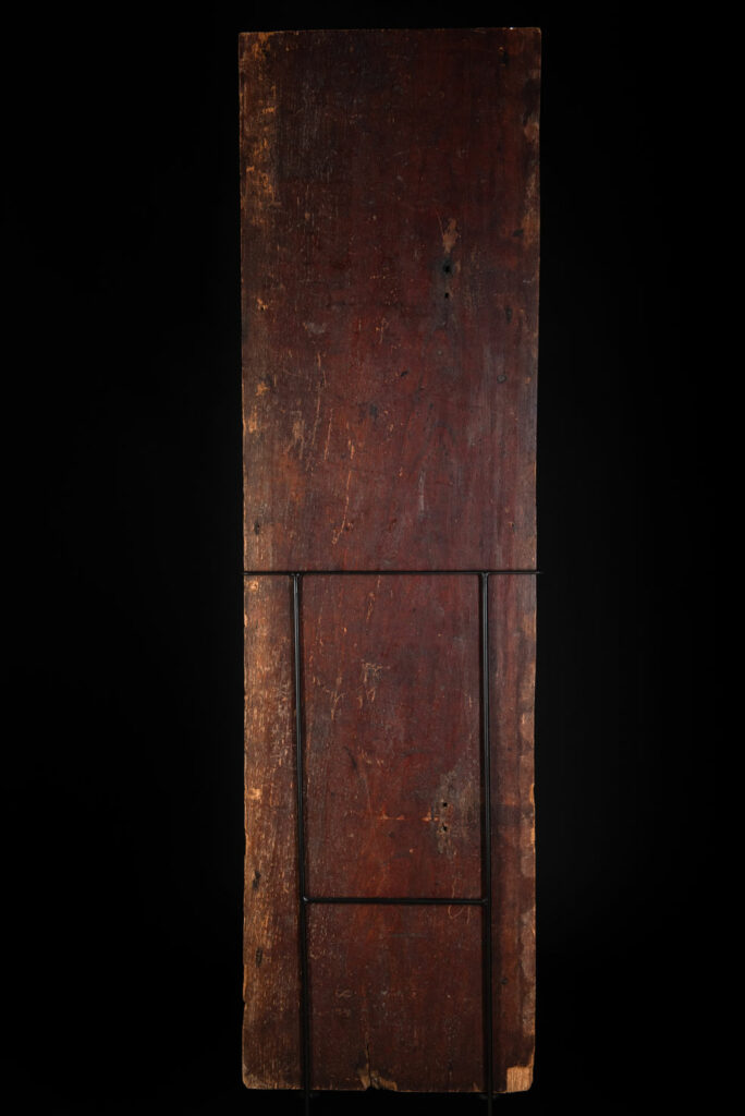 Ancestor panel from the Paiwan tribe, carved with a figure wearing a hat adorned with eagle feathers, a symbol of valor. His face is encircled by two snakes merging into one, and flanked by two additional sacred snakes on each side.