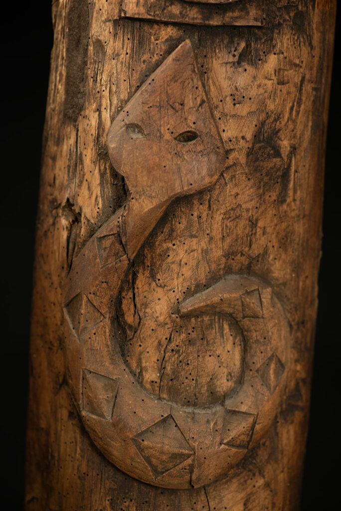 Ancient Paiwan tribe pillar , part of the inside partition, carved with human faces and sacred snakes.