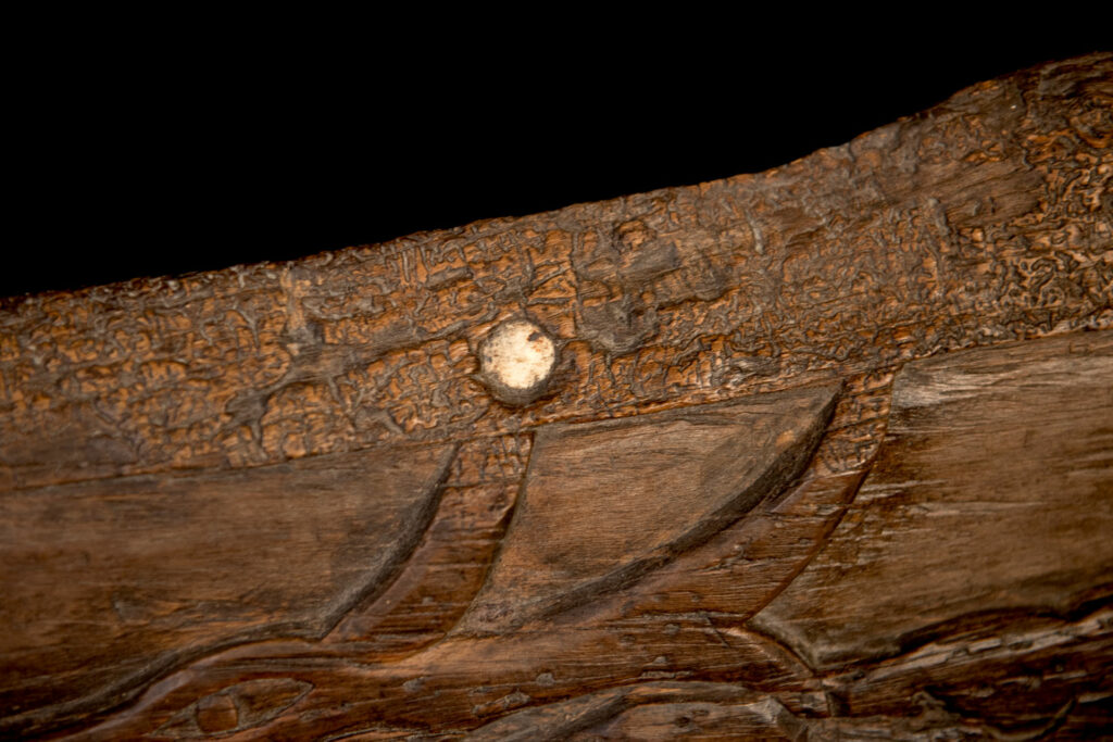 Ancient 19 century Paiwan tribe house eave carved with four human faces and three deers, two big and one small in the middle.
