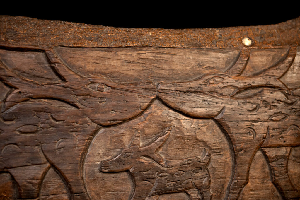 Ancient 19 century Paiwan tribe house eave carved with four human faces and three deers, two big and one small in the middle.