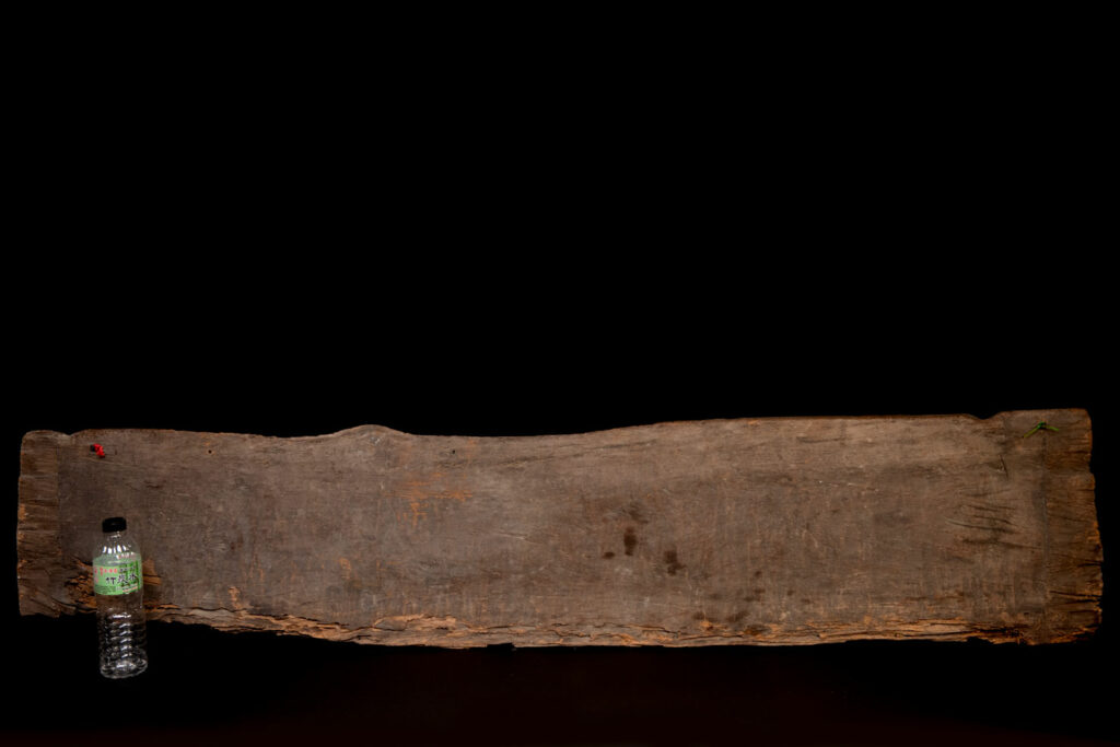 Ancient 19 century Paiwan tribe house eave carved with four human faces and three deers, two big and one small in the middle.