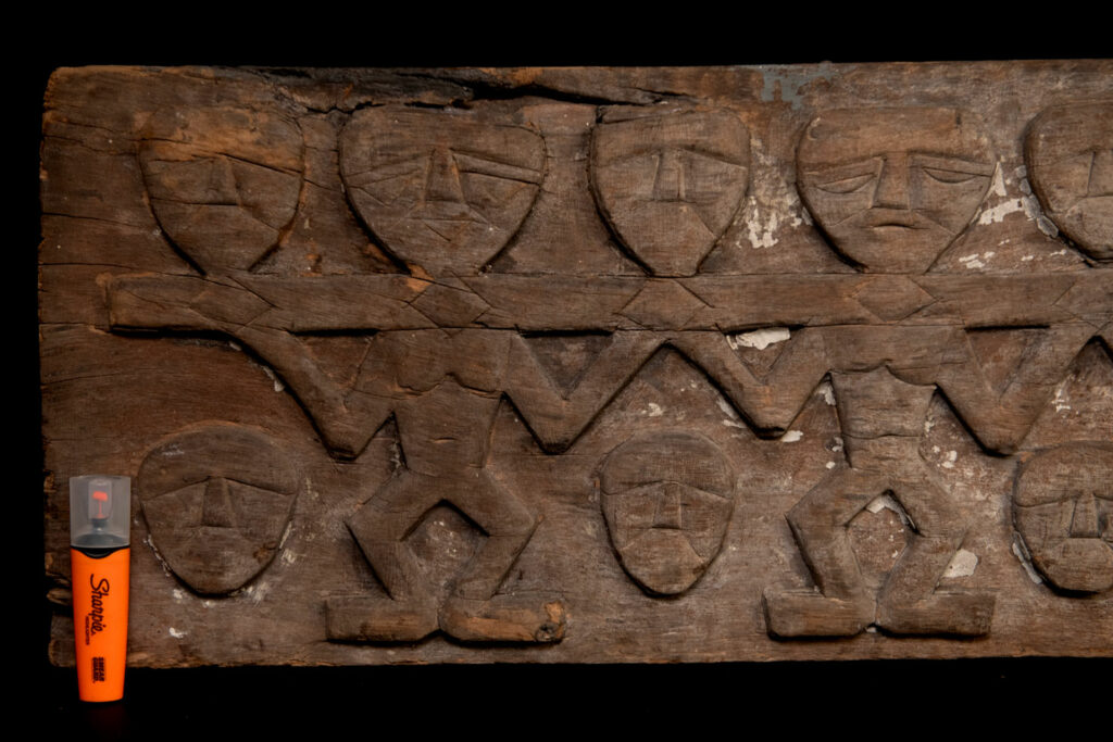 Paiwan tribe house eave carved with warriors drinking millet wine from a double cup — a symbol of unity — after a victory. Taiwan