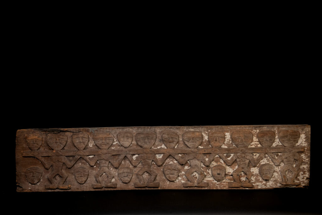 Paiwan tribe house eave carved with warriors drinking millet wine from a double cup — a symbol of unity — after a victory. Taiwan