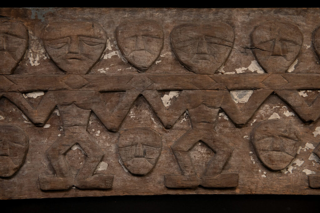Paiwan tribe house eave carved with warriors drinking millet wine from a double cup — a symbol of unity — after a victory. Taiwan