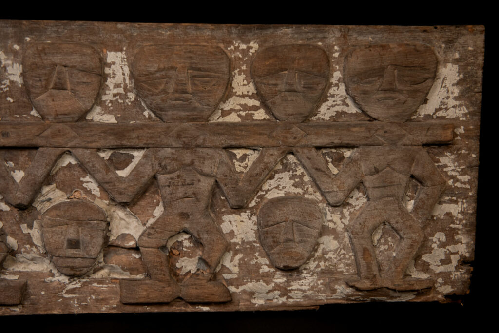 Paiwan tribe house eave carved with warriors drinking millet wine from a double cup — a symbol of unity — after a victory. Taiwan