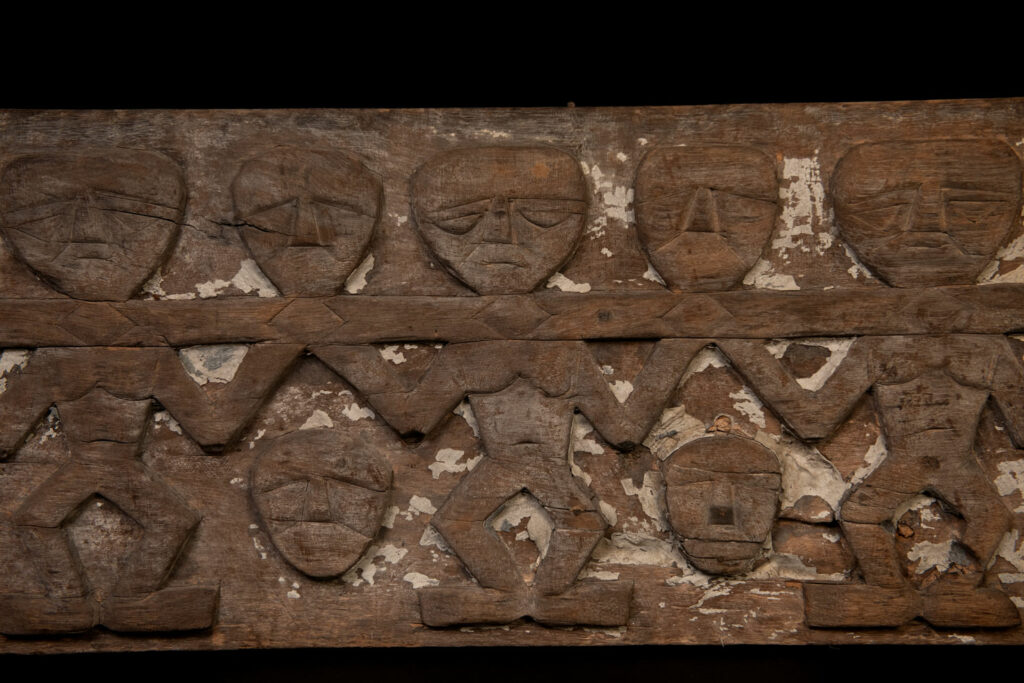 Paiwan tribe house eave carved with warriors drinking millet wine from a double cup — a symbol of unity — after a victory. Taiwan