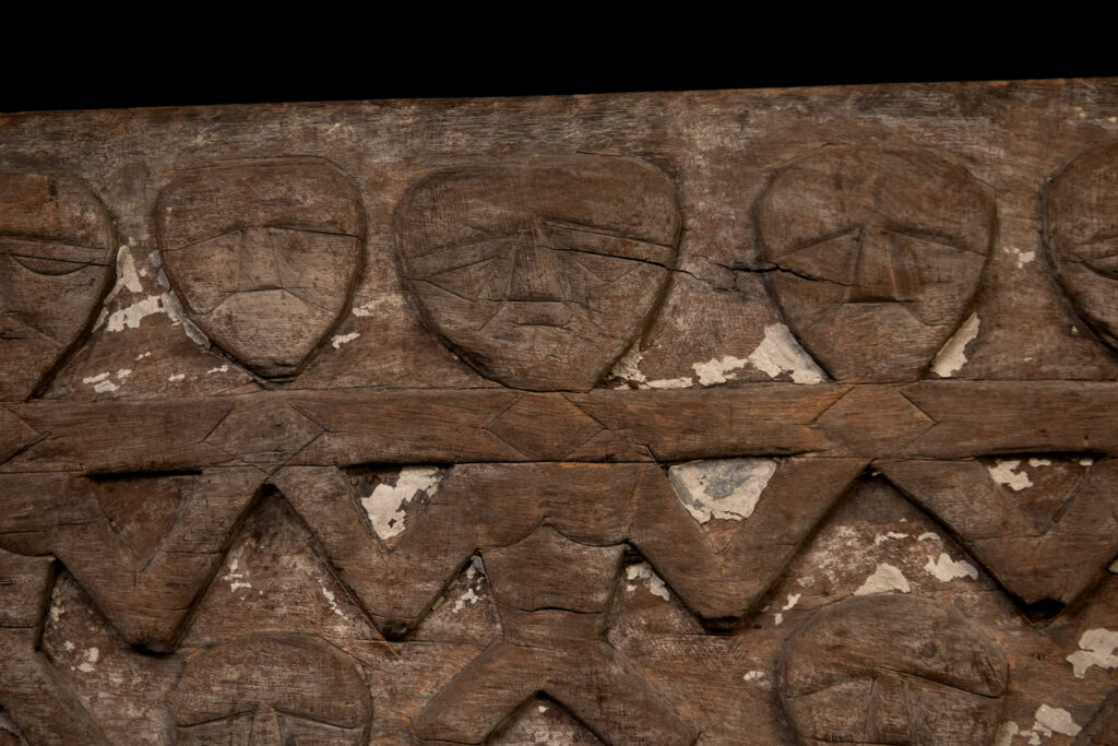 Paiwan tribe house eave carved with warriors drinking millet wine from a double cup — a symbol of unity — after a victory. Taiwan