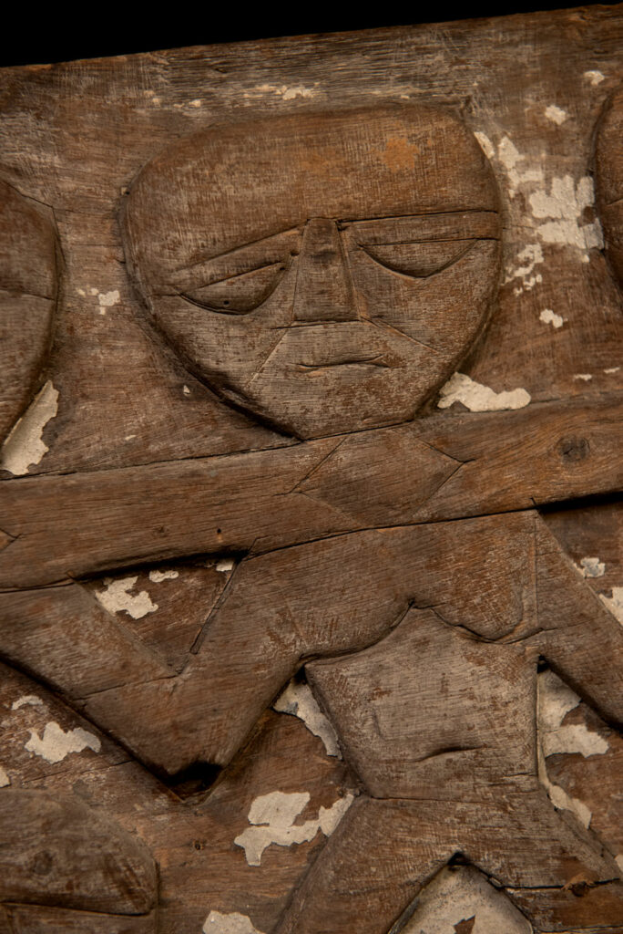 Paiwan tribe house eave carved with warriors drinking millet wine from a double cup — a symbol of unity — after a victory. Taiwan