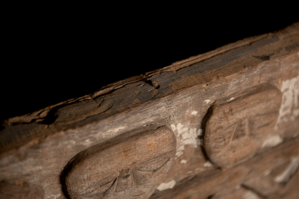 Paiwan tribe house eave carved with warriors drinking millet wine from a double cup — a symbol of unity — after a victory. Taiwan