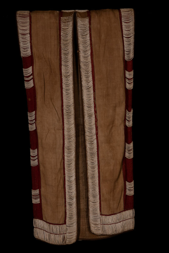Long Atayal tribe sleeveless tunic with an open front and no collar. Made from linen and decorated with dark red wool, its most striking feature lies in the elaborate use of cylindrical clam-shell beads, which are carefully embedded into the fabric in both horizontal and vertical alignments.