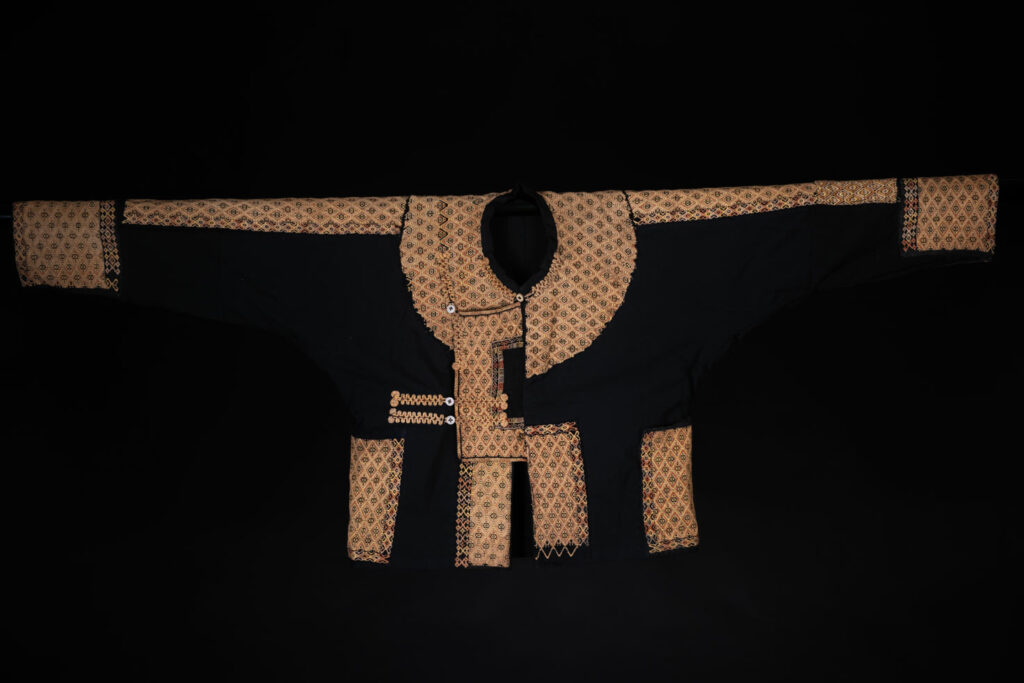 Male sleeve jacket from Rukai tribe , Black cotton and embroidered cloth pieces . This long sleeved short jacket is worn by noble men.