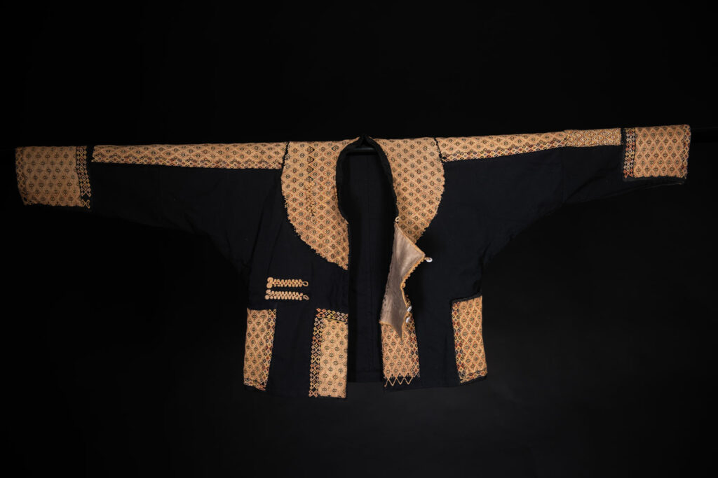 Male sleeve jacket from Rukai tribe , Black cotton and embroidered cloth pieces . This long sleeved short jacket is worn by noble men.
