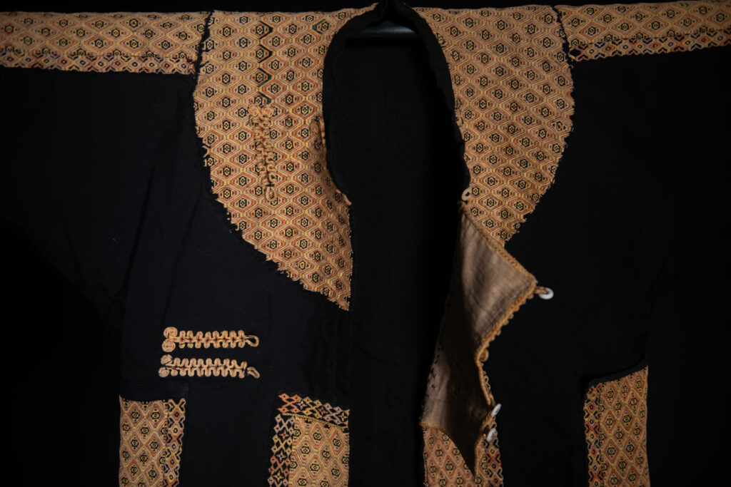 Male sleeve jacket from Rukai tribe , Black cotton and embroidered cloth pieces . This long sleeved short jacket is worn by noble men.