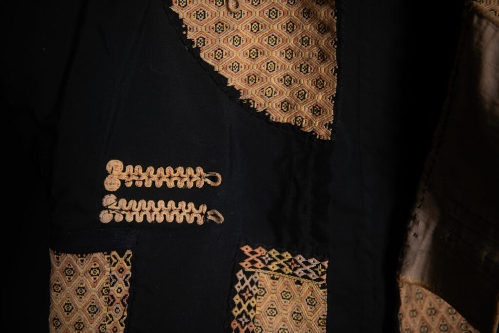 Male sleeve jacket from Rukai tribe , Black cotton and embroidered cloth pieces . This long sleeved short jacket is worn by noble men.
